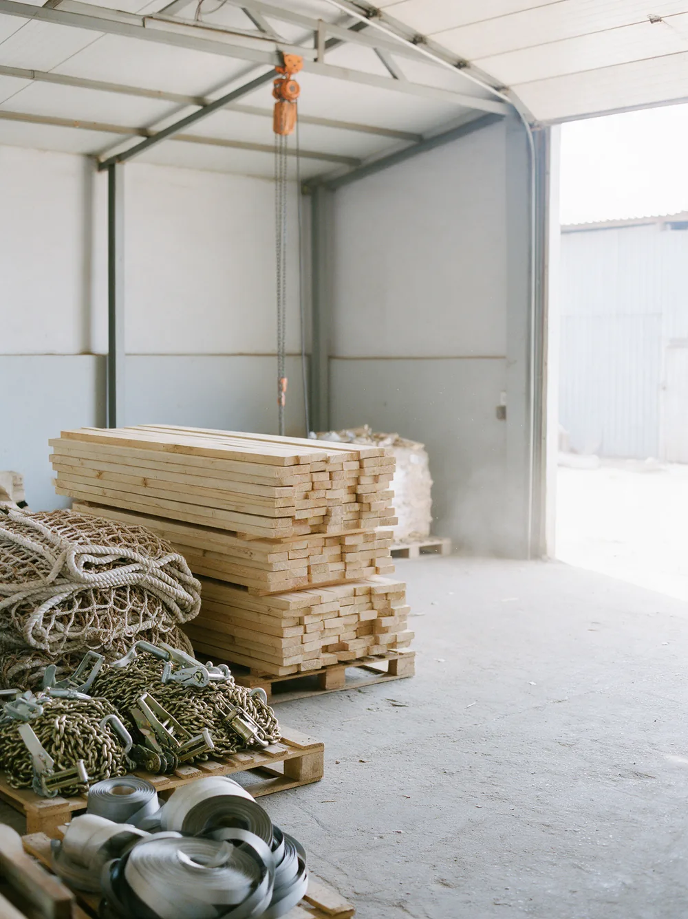 Timber dunnage boards, lashing chains and cargo nets on pallets.